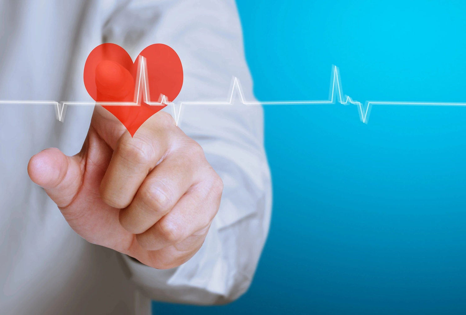 Hand touching a digital heart with heartbeat line.