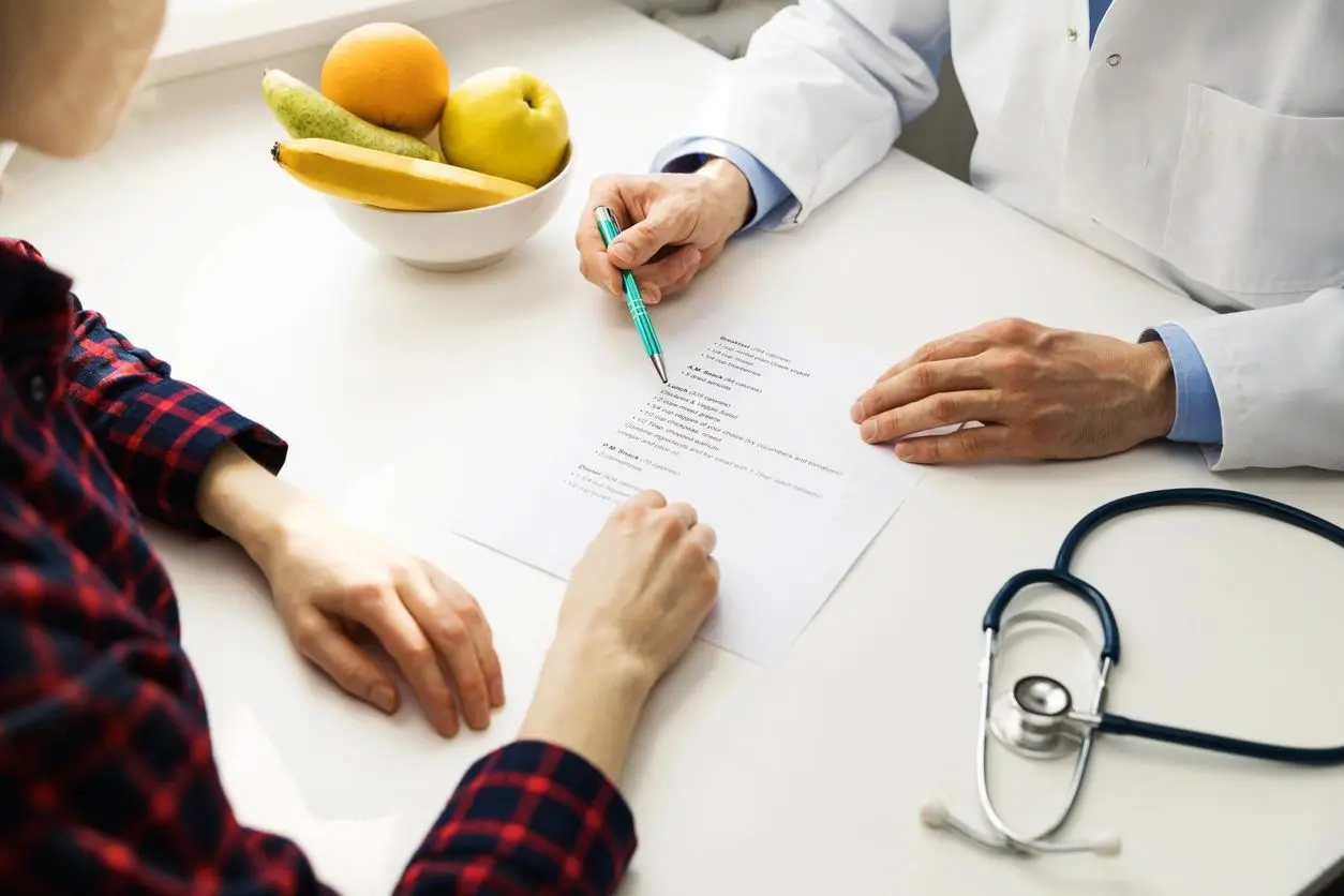 Doctor explaining medical results to a patient at the consultation desk.