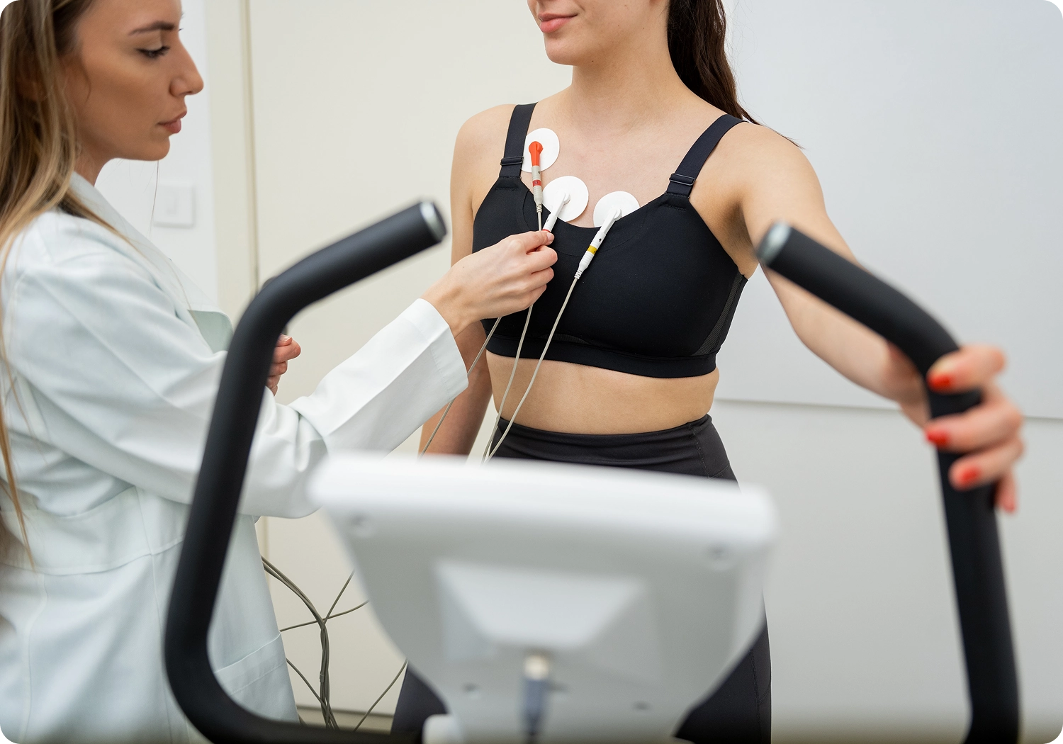Woman undergoing cardiac stress test on treadmill.